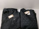 a pair of black nike jackets sitting on top of a white table