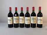 six bouteilles de vin sont alignées sur une table