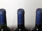 three bottles of wine are lined up on a table