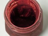 a jar of jam sitting on a table with a spoon in it