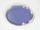 a blue plate with a white rim on a white table
