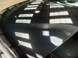 a black car parked in a parking lot next to a building