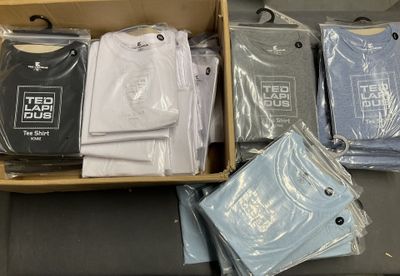 a lot of t - shirts in a box on a table