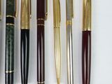 many different types of pens and pencils laid out on a table