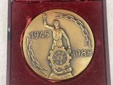 an image of a gold medal in a red box on a white surface