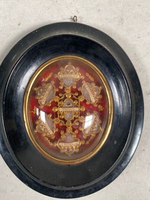une assiette noire ornée d'un motif doré et rouge