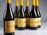 six bouteilles de vin sont alignées sur une table