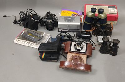 many different types of cameras and accessories on the table