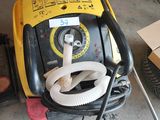 a yellow and black machine that is sitting in a garage