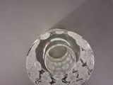 a glass candle holder with a flower design on it