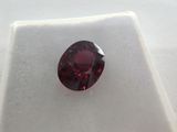 a close up of a red diamond on a white surface