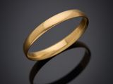 a gold wedding ring on a black background