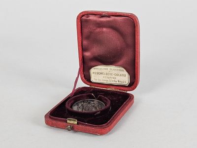 un petit étui rouge contenant une pièce de monnaie