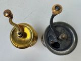 two different types of old fishing reels on the table