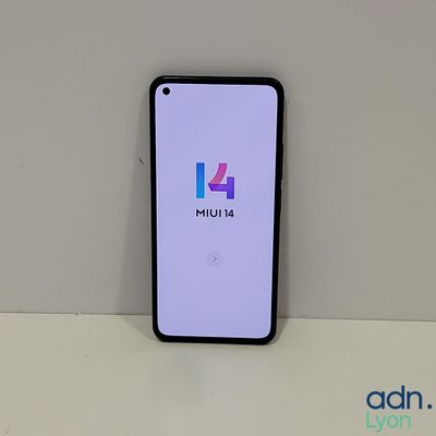 a close up of a phone on a table with a logo on the screen