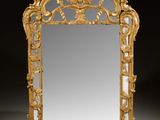 an ornately carved mirror with a gold frame on a black background