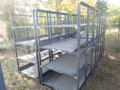 a metal cage with several shelves on it in the grass