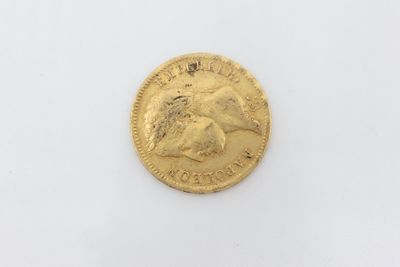 a close up of a gold coin on a white surface