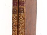 two old books sitting on top of each other on a table