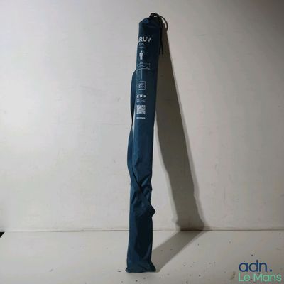 un parapluie bleu appuyé contre un mur blanc