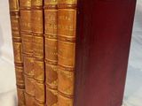 un ensemble de cinq livres anciens reliés en cuir sur fond blanc