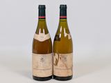 two bottles of wine sitting next to each other on a white surface