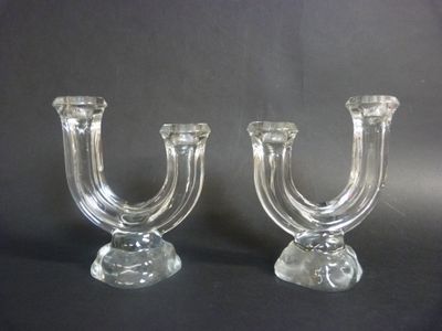 two clear glass candlesticks on a black background
