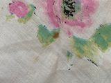 a close up of a pink and green flower on a white cloth