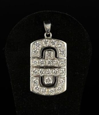 un pendentif en or blanc et diamants sur lequel figure la lettre « u »