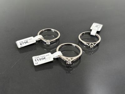 trois bagues en argent sont posées sur une table noire