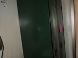 a green locker next to a sink in a room