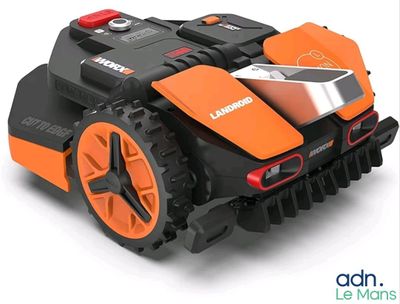 une tondeuse robotisée orange et noire posée sur une surface blanche