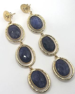 a close up of a pair of earrings on a white surface