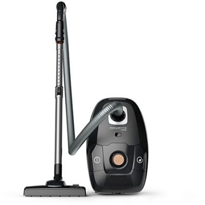 un aspirateur noir et argenté muni d'une poignée filaire, à côté d'un réservoir