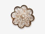 un gros plan d'une broche en forme de fleur sur fond blanc