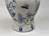 a blue and white vase sitting on a white surface