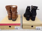 two pairs of women ' s boots sitting on top of a cardboard box