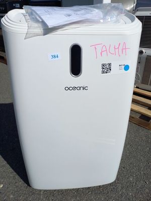 une poubelle sur laquelle est collé un autocollant, devant un immeuble