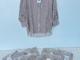 une chemise rayée blanche et marron posée sur une table blanche