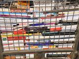 many books stacked on top of each other in a wire basket