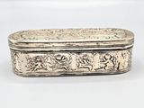 an old silver box with a design on it on a white surface