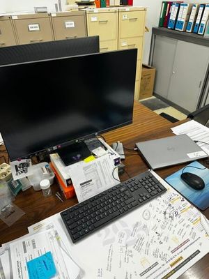 un bureau sur lequel se trouvent un ordinateur, un clavier, une souris et des papiers
