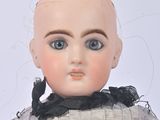a close up of a doll wearing a dress and gloves
