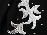 a close up of a black jacket with silver sequins on it