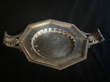 un plat ancien en argent, orné d'un motif décoratif sur fond noir
