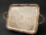 an ornate silver tray with handles and handles on a black background
