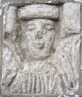 a stone carving of a man with a hat on