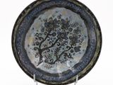 a blue and black plate with a tree on it