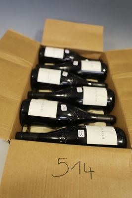 several bottles of wine are in a cardboard box on a table