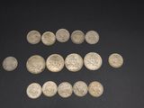 a close up of a pile of silver coins on a black surface
